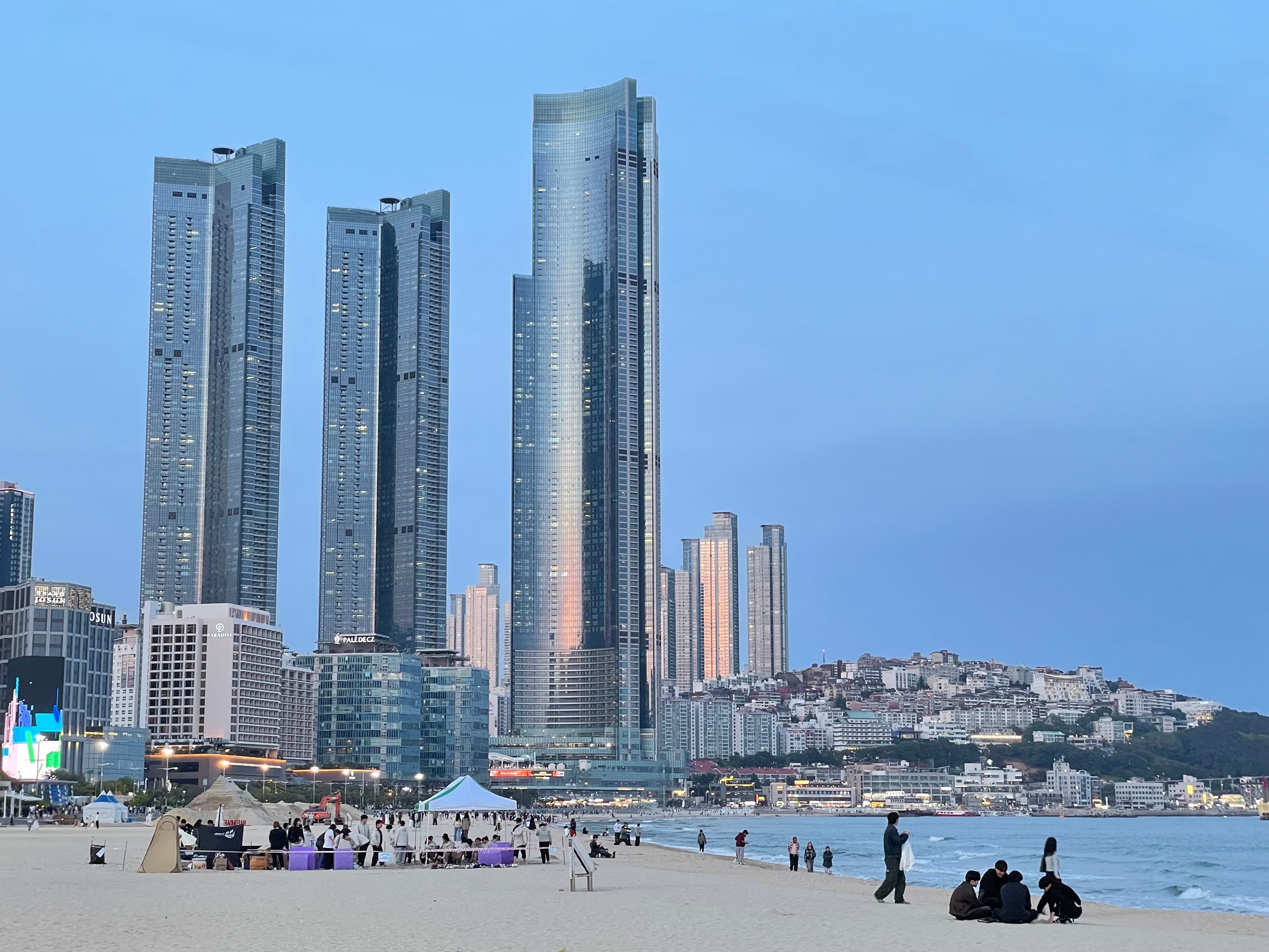 Haeundae Beach at night with the Signiel Busan tower glowing against the dark sky