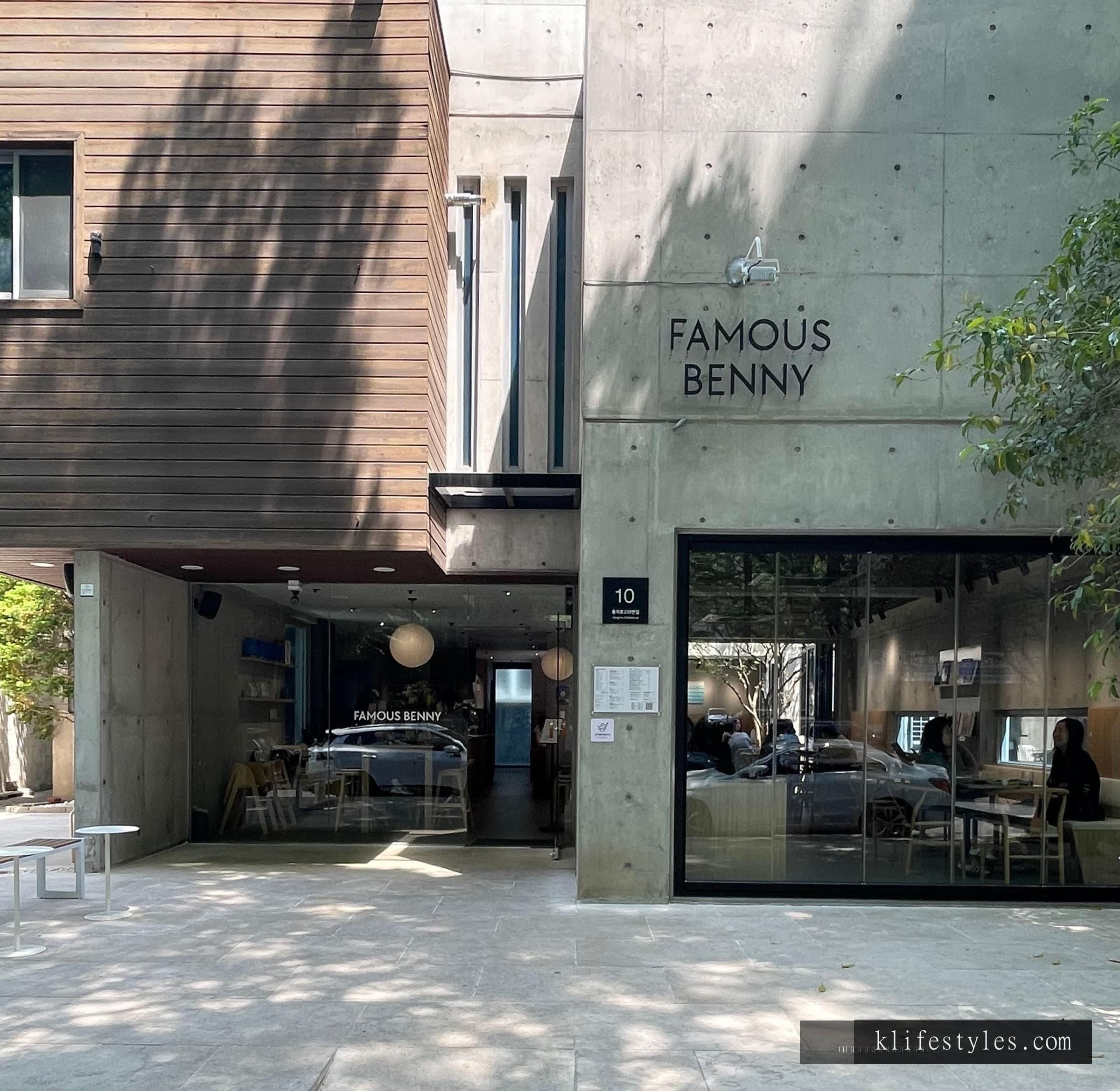 Famous Benny café interior in Changwon Garosugil — warm afternoon light filtering through large windows onto wooden tables